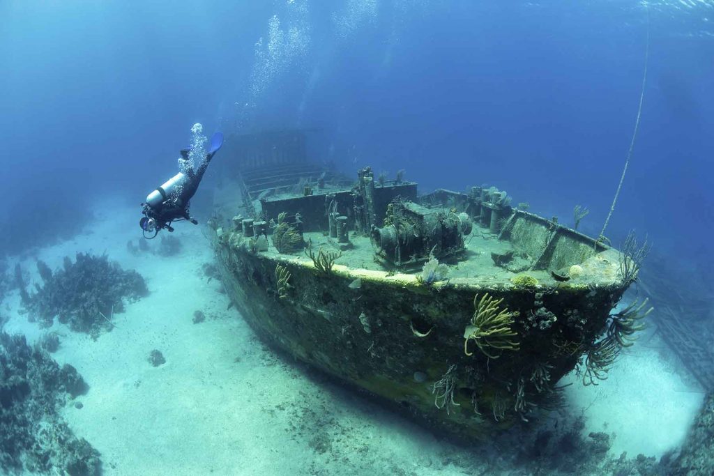 a-diver-underater-exploring-the-wreck-of-a-sunken-RPZYZLK.jpg
